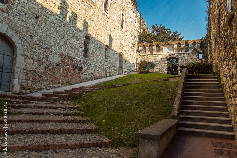 the beautiful medieval castle of the city of Brescia in the evening against a bright blue sky. Part of Brescia castle. Castello di Brescia, Lombardy, Italy. Travelling to fortresses in europe