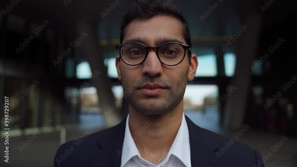 Portrait of Mixed race businessman wearing spectacles looking at camera dressed smartly outdoors Portrait of Mixed race businessman wearing spectacles looking at camera dressed smartly outdoors