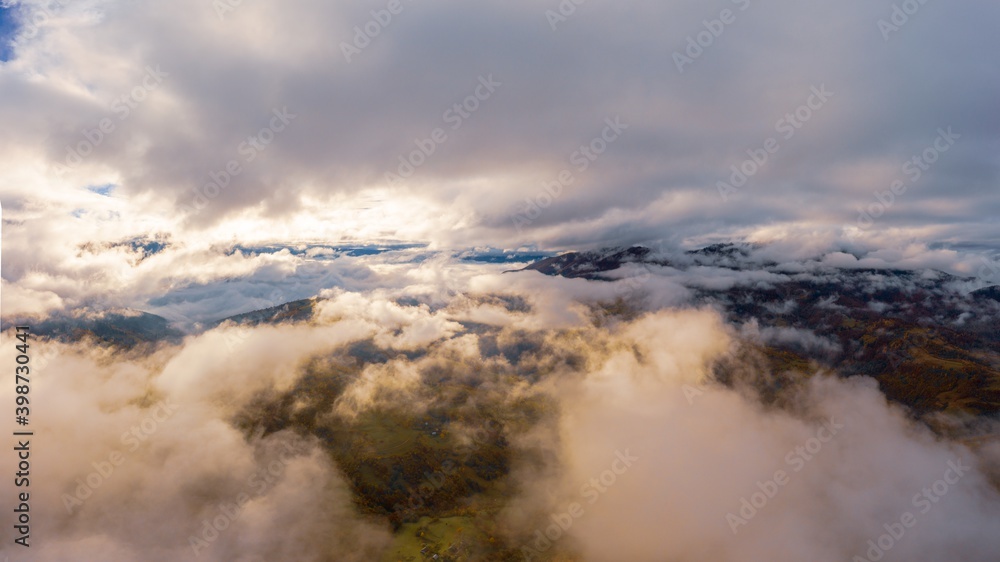 Flight through blue sky with clouds over mountain