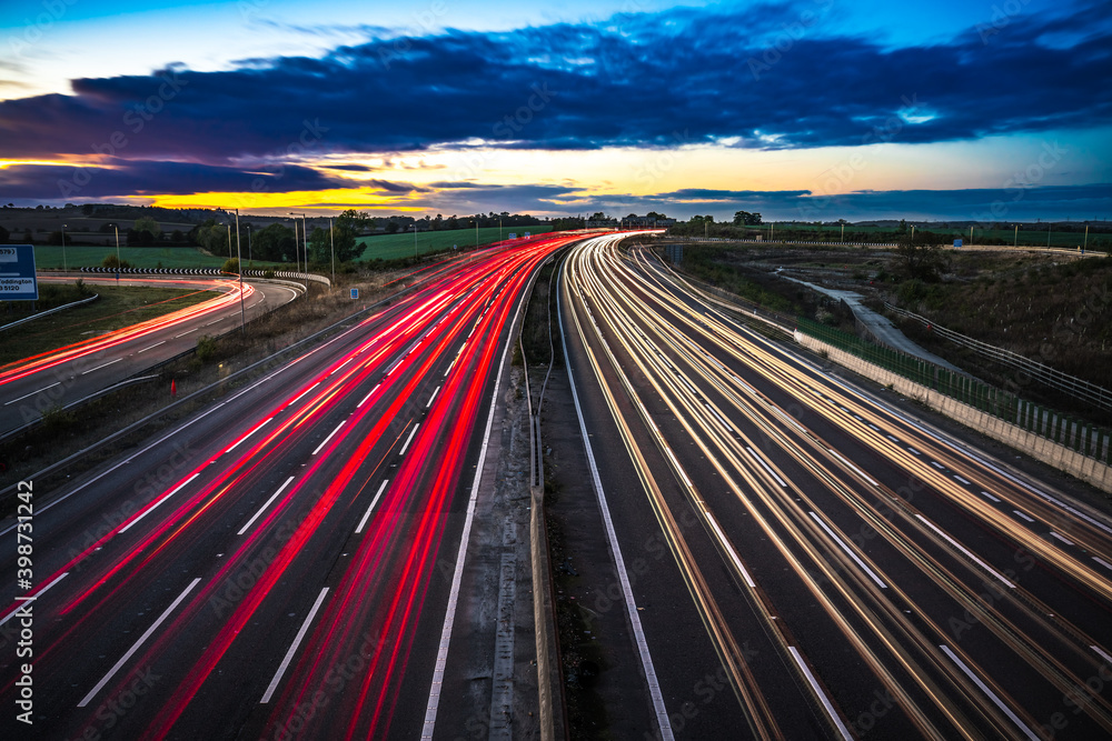 Colorful sunset at M1 motorway near Flitwick junction with cars light trails. United Kingdom