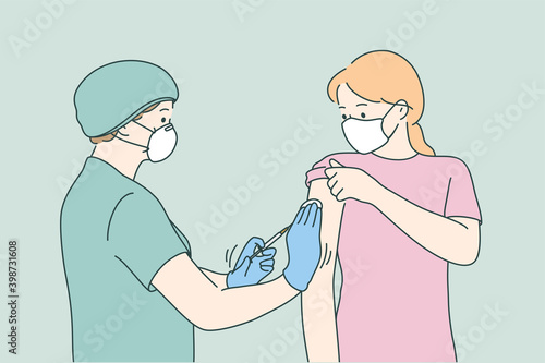 Woman doctor in protective medical mask and uniform holding syringe before making injection to young female patient in medical clinic. Vaccination, Covid-19 coronavirus vaccine concept 