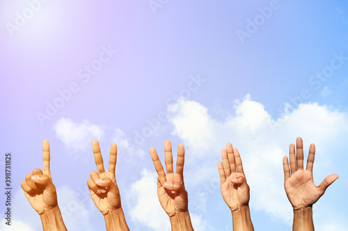 Set of hands counting from one to five behind of fresh air with blue sky and clouds background with copy space for wallpaper or banner