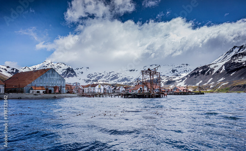 Condemned whaling station on South Georgia surrounded by snow capped mountain peaks.