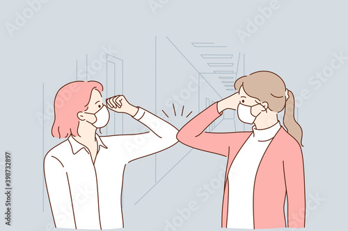 Protection from COVID-19 pandemic, healthcare and working during outbreak concept. Female colleagues in protective face masks greeting each other with bumping elbows at workplace vector illustration