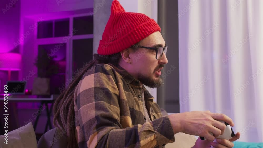 Excited man playing video games on modern console next gen 2020, new era of consoles, white gamepad, male at home play games Excited man playing video games on modern console next gen 2020, new era of consoles, white gamepad, male at home play games