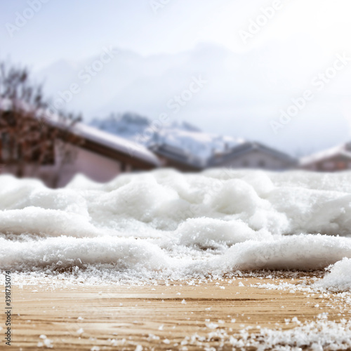Fresh snow on a wooden table with an alpine view of the mountains