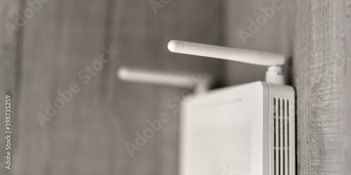 Cuadro en lienzo white colored wifi router with long antenna tendrils hangs on wooden wall of hom