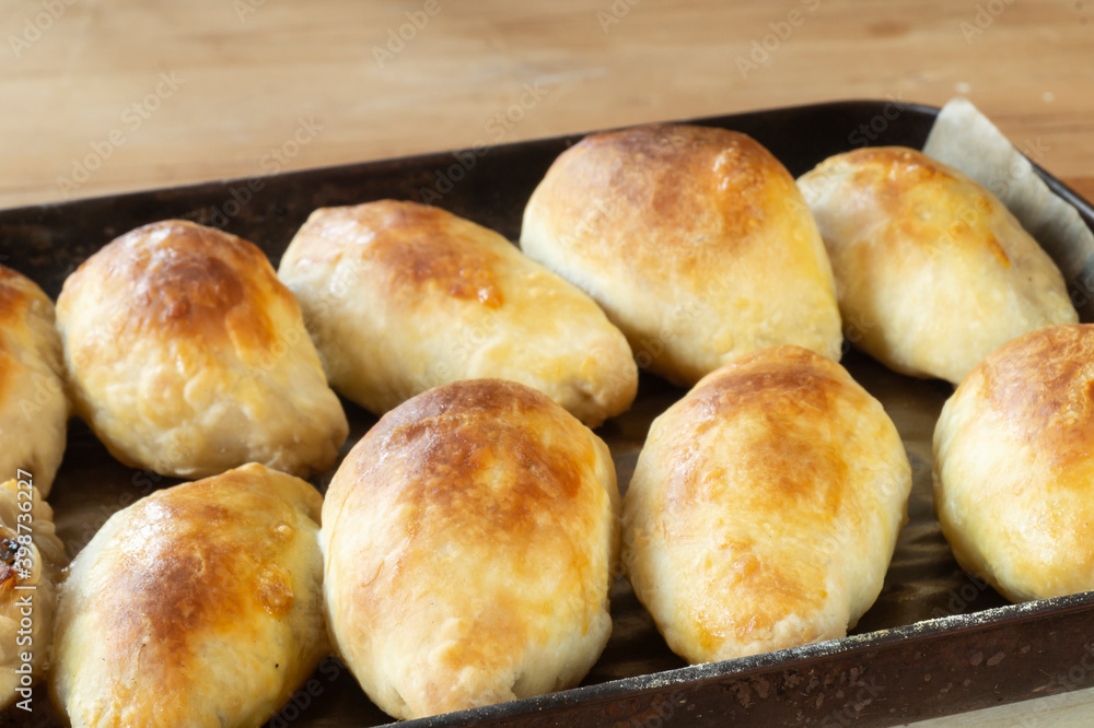 Home pies in black pan on wooden table