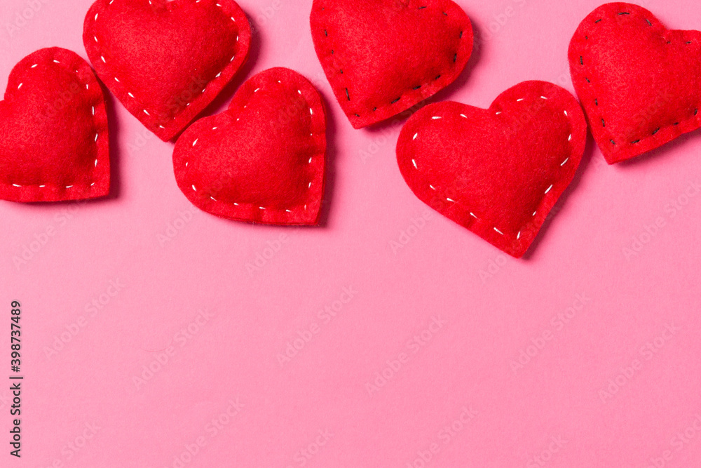 Composition of textile red hearts on colorful background with empty space for your design. Top view of St. Valentine's day concept Composition of textile red hearts on colorful background with empty space for your design. Top view of St. Valentine's day concept