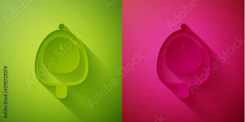 Paper cut Toilet urinal or pissoir icon isolated on green and pink background. Urinal in male toilet. Washroom, lavatory, WC. Paper art style. Vector.