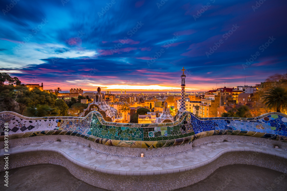 Obraz premium Beautiful sunrise in Barcelona seen from Park Guell. Park was built from 1900 to 1914 and was officially opened as a public park in 1926. In 1984, UNESCO declared the park a World Heritage Site