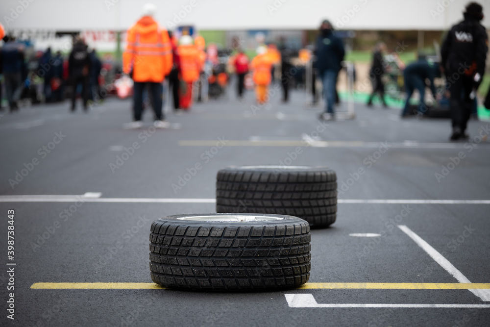 Wet race concept, motorsport car rain tires on asphalt circuit starting line grid selective focus