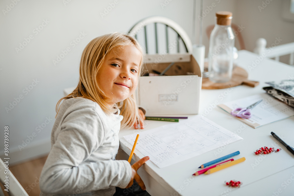Smiling girl at home doing homework Smiling girl at home doing homework