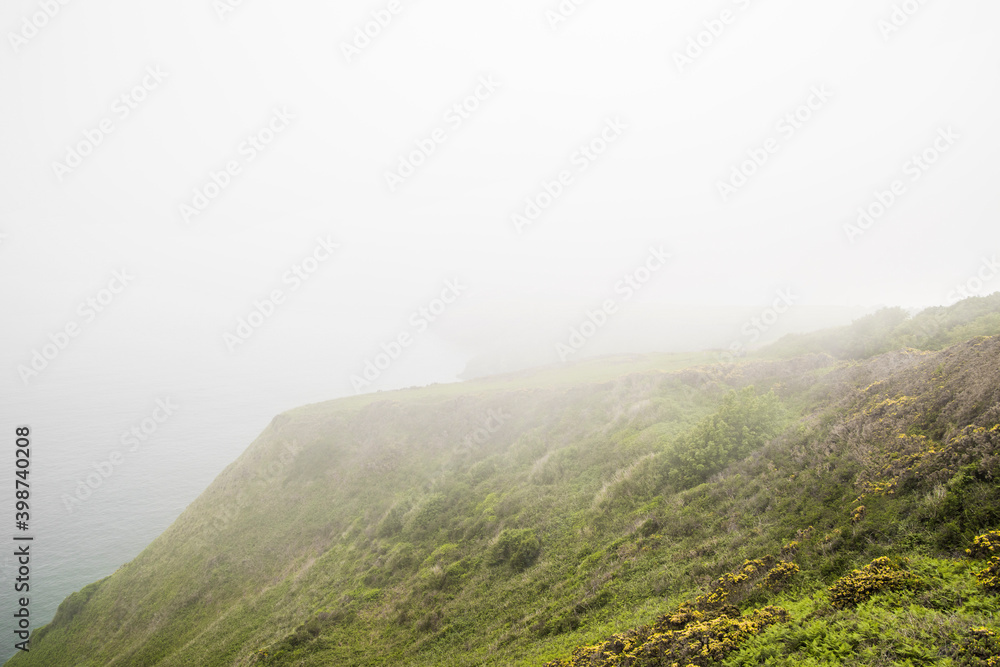 Irish landscape | foggy cliffs | mountain edge in mist | fog around the green hill | Ireland Howth Cliffside | Hiking And Trekking | 