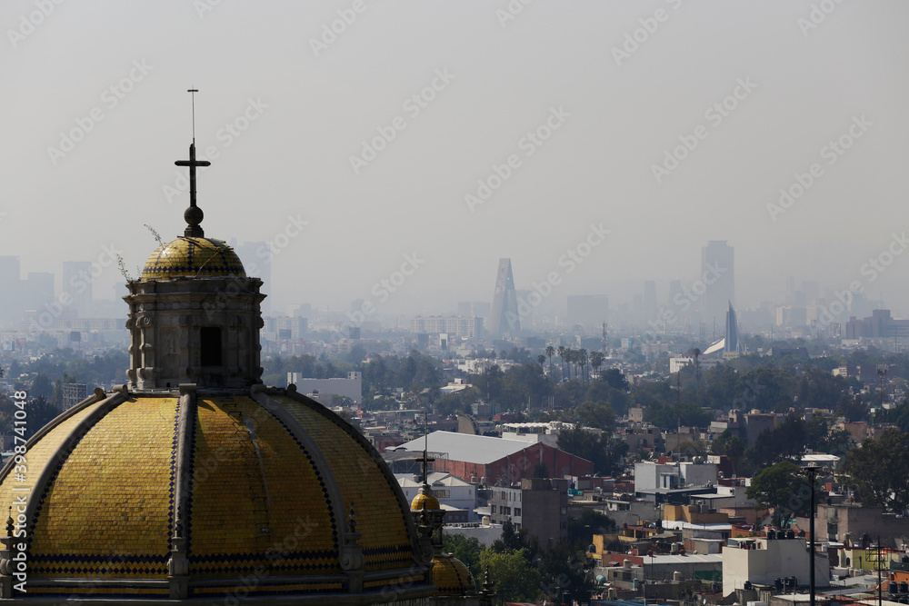 Aerial view of the Basilica of the Virgin of Guadalupe dome backgrounded by a polluted sky of Mexico City, Mexico.