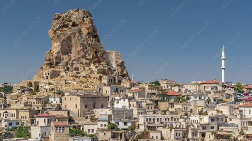 View of Ortahisar town old houses in rock formations from Ortahisar Castle aerial timelapse. Cappadocia. Nevsehir Province. Turkey. Blue sky View of Ortahisar town old houses in rock formations from Ortahisar Castle aerial timelapse. Cappadocia. Nevsehir Province. Turkey. Blue sky