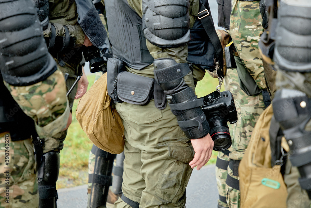 A soldier with a camera stands among the soldiers A soldier with a camera stands among the soldiers