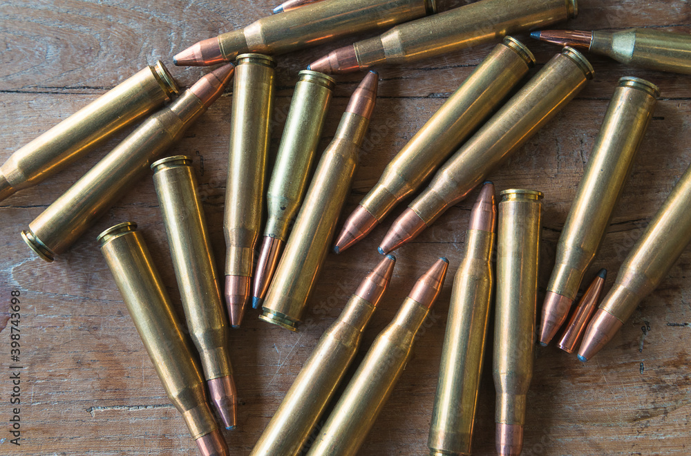 Many bullets on old wooden background