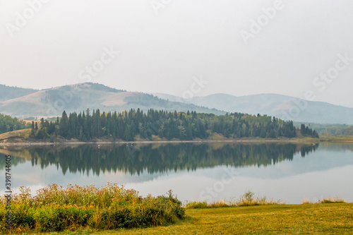 Reflections in the lake on a hazy morning. Chain Lakes Provincial Park  Alberta  Canada