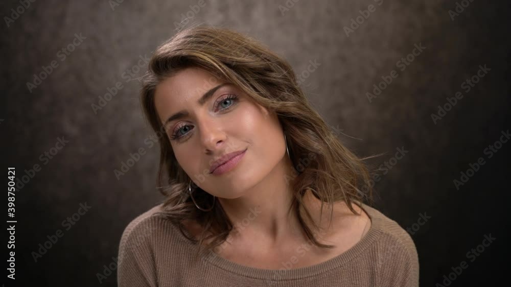 Cute woman looks dreamily turns toward camera flirts with eyes smile Cute woman looks dreamily turns toward camera flirts with eyes smile
