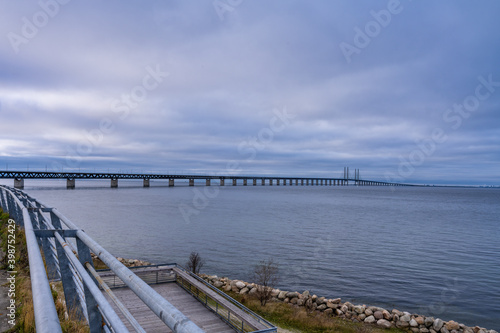 Fototapeta Naklejka Na Ścianę i Meble -  The Sound Bridge, the bridge and underwater tunnel connecting Malmo, Sweden with Copenhagen, Denmark. Beautiful sunset sky in the background