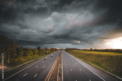 Stormy skies over a quiet motorway, evening commute. Driving road trip