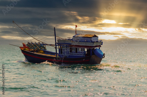 Vietnamese fishing boat for fish and squid. Open sea. Open water at bright sunset