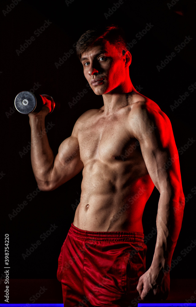 Muscular athlete man exercise on a black background