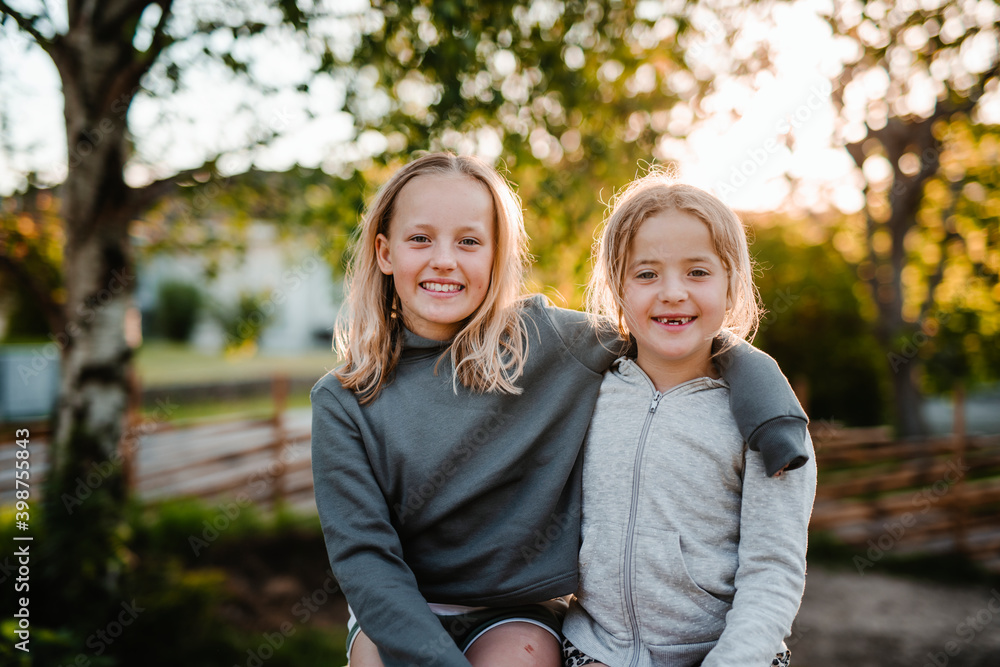 Smiling sisters looking at camera Smiling sisters looking at camera