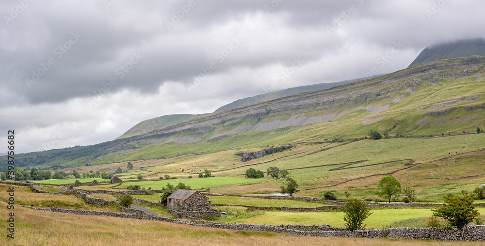 Cotterdale, Yorkshire Dales National Park, York, Uk - A view of an old stone barn, sheep and the rolling landscape of the Yorkshire Dales.