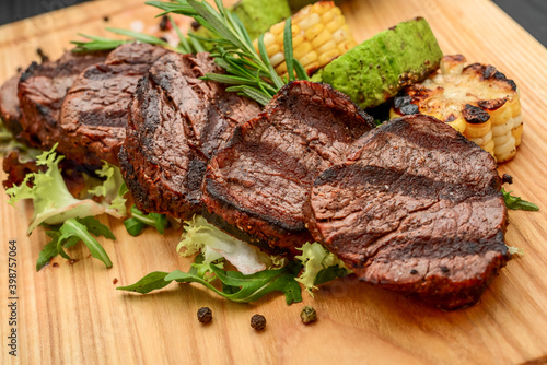 Grilled beefsteaks on cutting board - dinner preparation photo