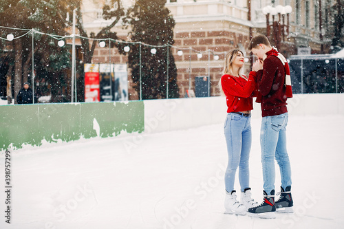 Fototapeta Naklejka Na Ścianę i Meble -  Couple in a ice arena. Elegant girl in a red sweater.