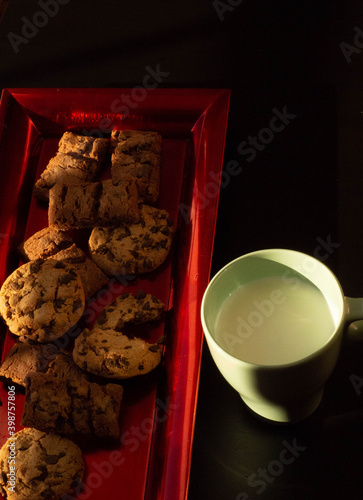 cookie thay with chocolate chips and cup of the milk photo