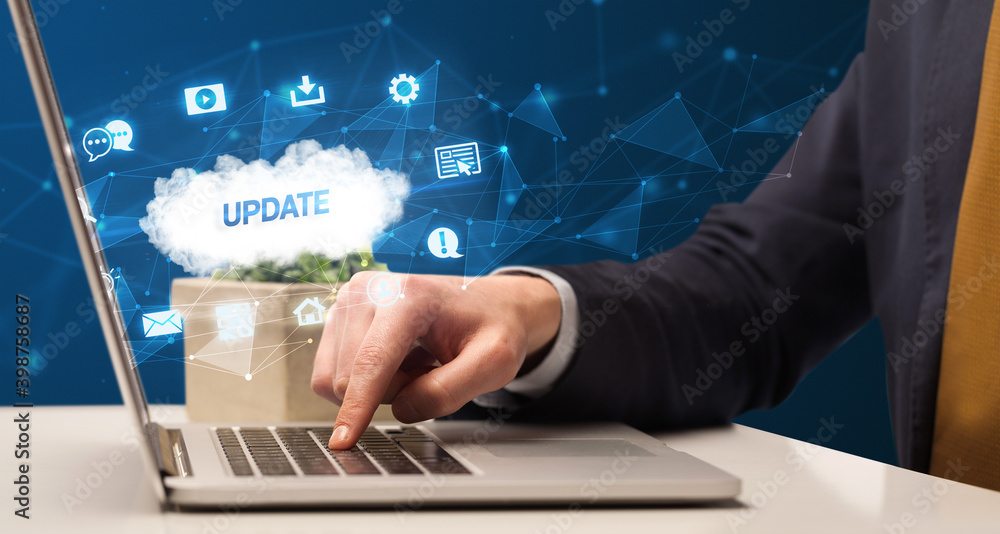 Businessman working on laptop with UPDATE inscription, modern technology concept Businessman working on laptop with UPDATE inscription, modern technology concept