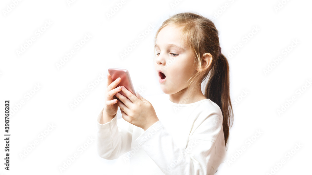 Little caucasian girl holding a smartphone in her hands and is greatly amazed looking at it Little caucasian girl holding a smartphone in her hands and is greatly amazed looking at it