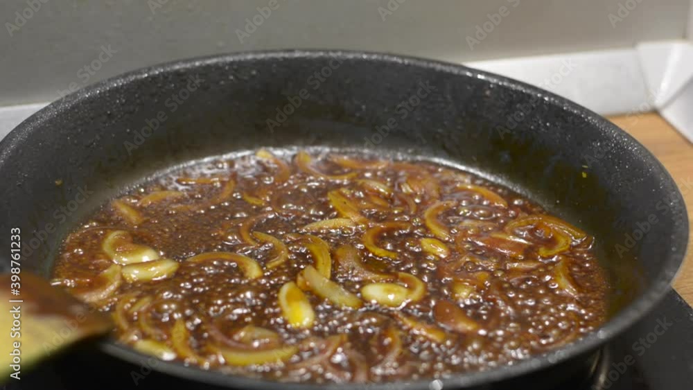 Chopped onions caramelizing in the frying pan. Medium simmer. shallow depth of field. Chopped onions caramelizing in the frying pan. Medium simmer. shallow depth of field.