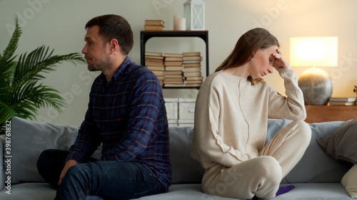 Slika na platnu Angry couple sit separate on couch ignore avoid talking after family fight misunderstanding