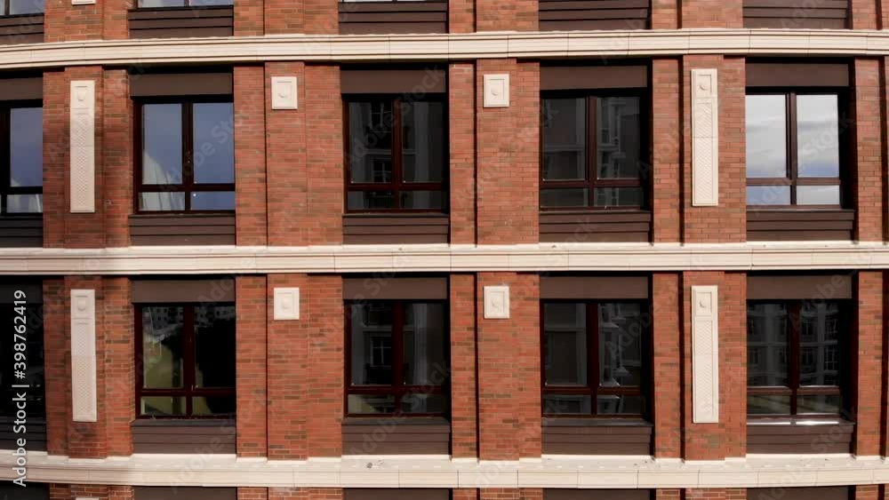 Multi-storey brick building with Windows. The flight on the drone is close to the building. Multi-storey brick building with Windows. The flight on the drone is close to the building.