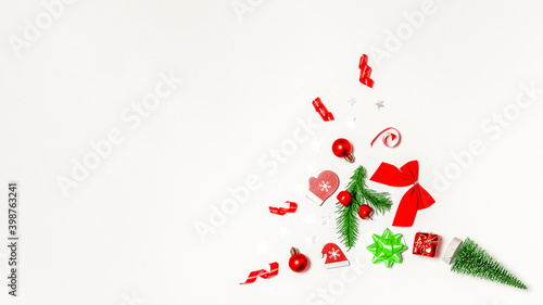 Holiday winter background. Stocking, gifts, winter tree, ribbon and bow in Christmas composition on white background for greeting card. Flat lay, top view, copy space.
