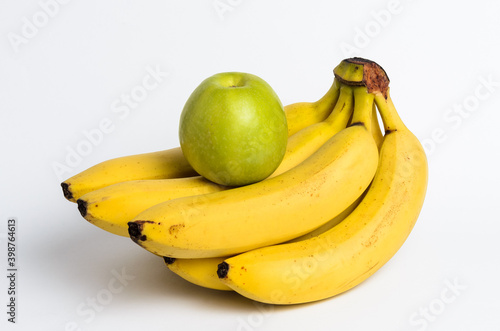 bunch of bananas and green apple on white background