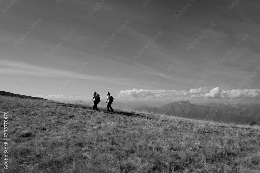 a couple of people walking on a hill