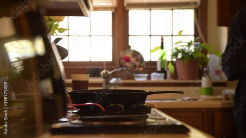 Older man Cooking Egg Breakfast with cast iron skillet on a cool bright morning.

