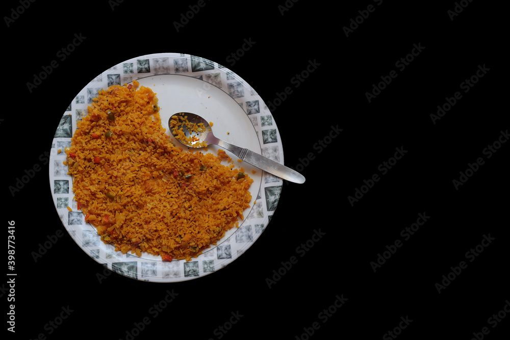 a top view of a plate of poha, a north indian dish spicy made of flattened rice chidwa with a spoon isolated in black background with space for text a top view of a plate of poha, a north indian dish spicy made of flattened rice chidwa with a spoon isolated in black background with space for text