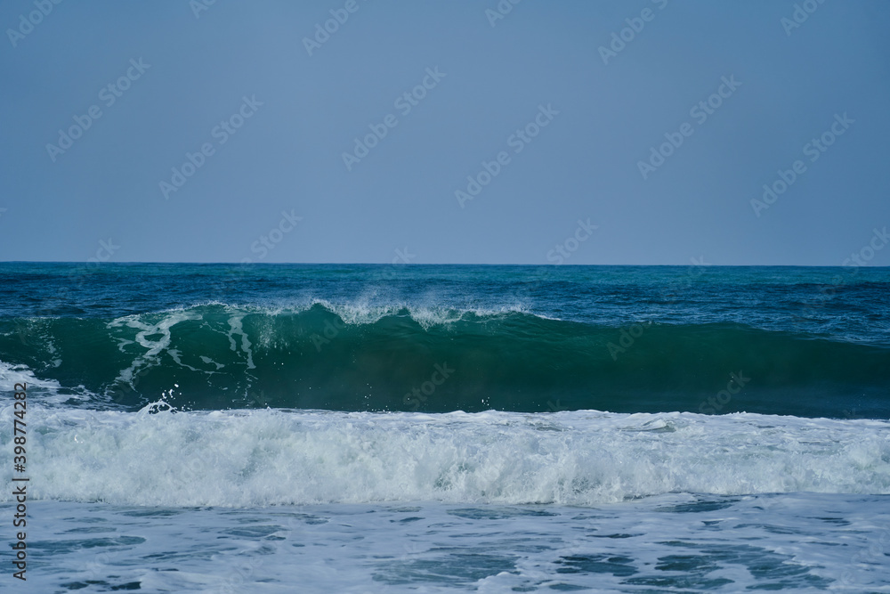 Obraz premium waves crushing in on the beach of the shoreline at Tayrona national park on the atlantic coast of Colombia in caribbean, South America