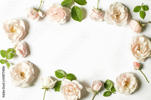 Floral frame wreath of white rose flower buds on white background. Flat lay, top view mockup.