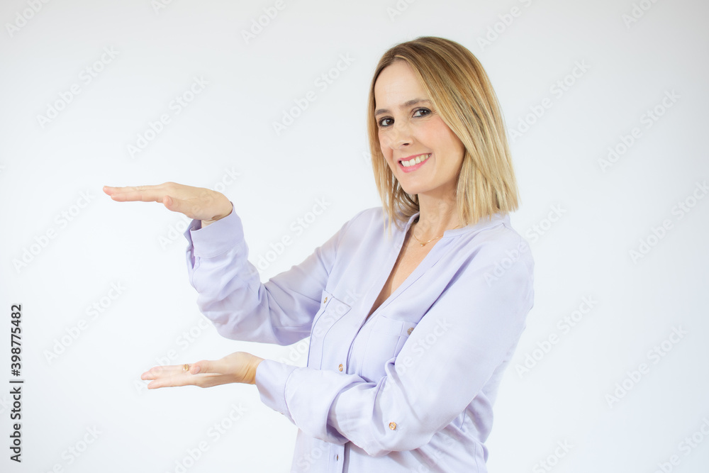 Young woman wearing casual shirt showing product with hands over white background. Young woman wearing casual shirt showing product with hands over white background.