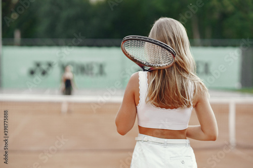 Great day to play Cheerful young woman in t-shirt. Woman holding tennis racket and ball. © hetmanstock2
