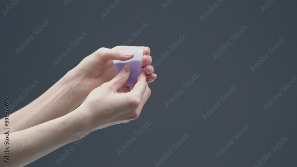 Woman hand take out menstrual cup with blood. Zero waste menstruation hygiene concept. Ecofriendly alternative for cycle Woman hand take out menstrual cup with blood. Zero waste menstruation hygiene concept. Ecofriendly alternative for cycle