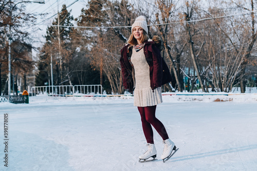 Girl skating on frozen lake in snowy winter park