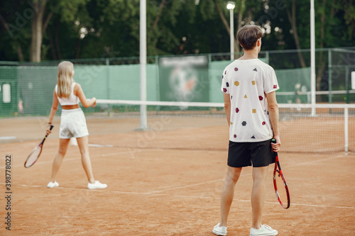 Young couple on tennis court. Two tennis players in a sport clothes. © hetmanstock2